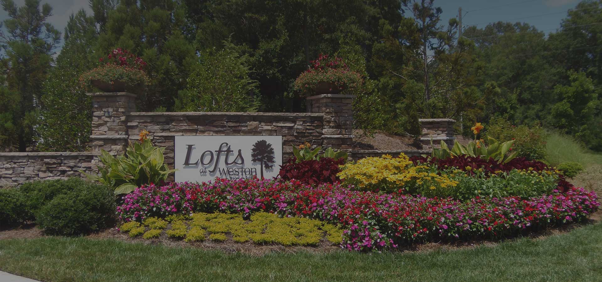 lofts sign with flower bed